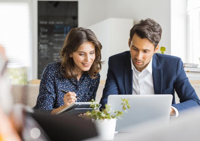 Deux conseillers en assurance étudient un dossier client sur ordinateur portable